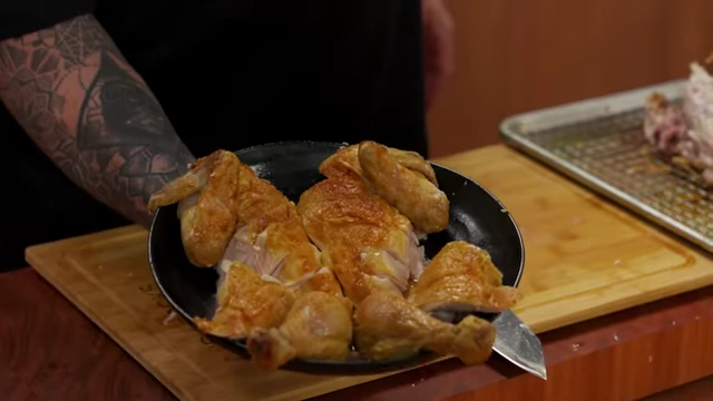 Plated, carved roasted chicken pieces, including drumsticks, thighs, and sliced breast