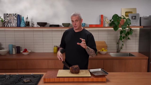 A chef explains how slice thickness depends on the cut of beef, demonstrating with hand gestures