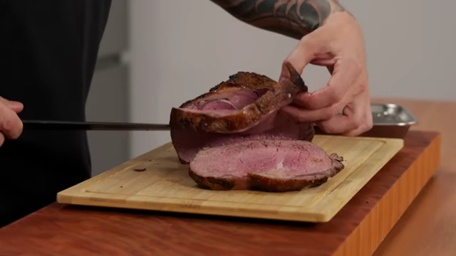 A close-up of beautifully sliced roast beef, showing consistent thickness and juiciness
