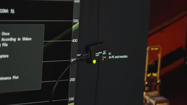 Close-up of the LDAT device measuring latency on the monitor