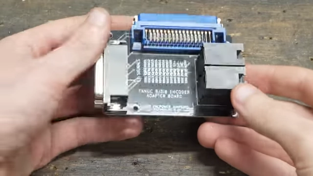 A custom encoder adapter board with a blue industrial connector