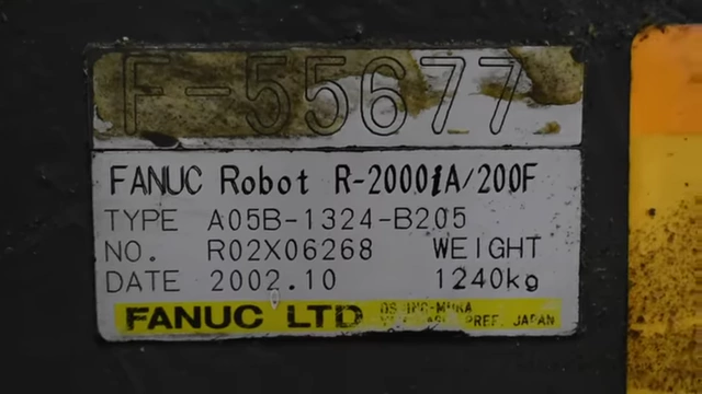 A close-up of the Fanuc R-2000 robot nameplate showing its weight in kilograms