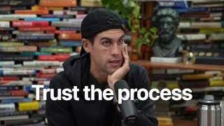 The text "Trust the process" is displayed over an image of Ryan Holiday.