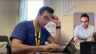 Ali Abdaal is shown at a desk, looking tired, during his time as a doctor.