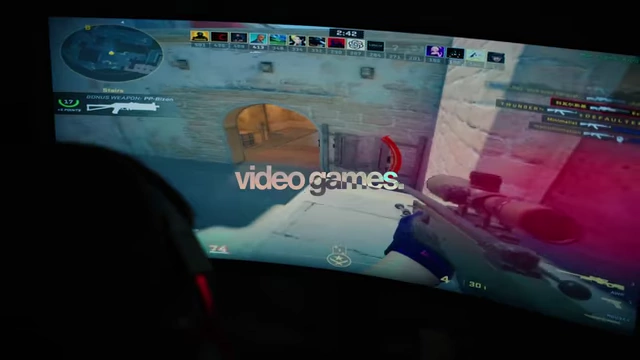 Person playing video games on a curved monitor.