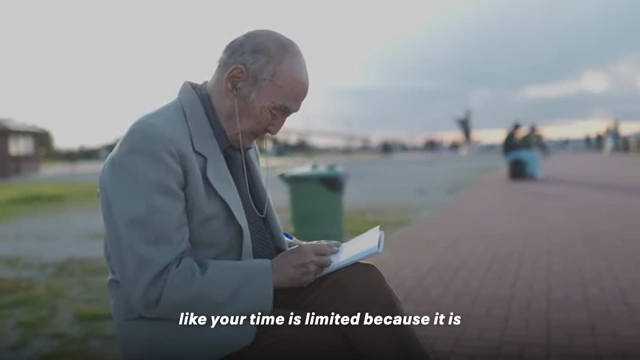 An older man writing in a notebook, symbolizing intentional living and reflection.