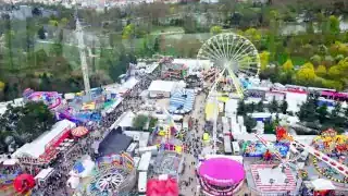 An aerial view of the Foire du Trône spring fair with numerous rides and large crowds.