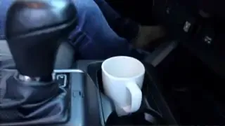 A coffee mug sits securely in the cup holder after the divider has been removed