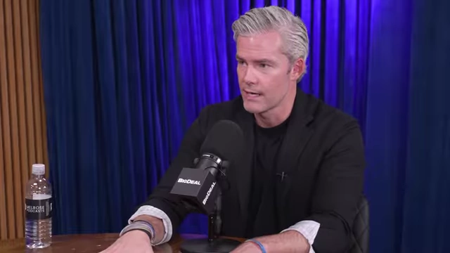 Ryan Serhant discussing his business structure with hand gestures, explaining how it aims to move people forward in real estate.