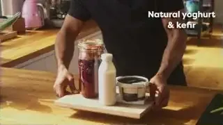 Natural yogurt and kefir displayed on a wooden tray.