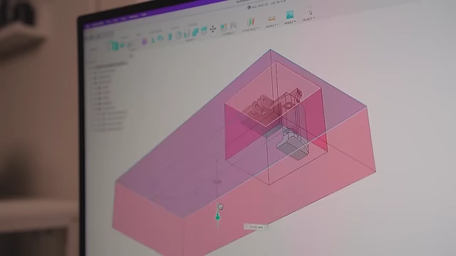 A 3D model in Fusion 360 highlighting a cut-out section for mechanical parts