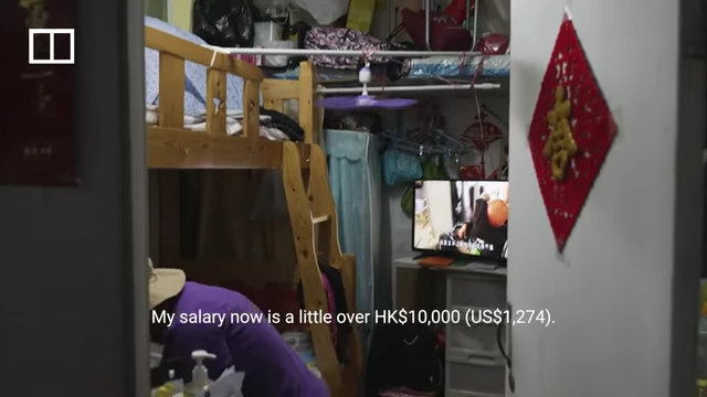 A wide shot of Auntie Ha's subdivided flat showing her living and sleeping arrangements.