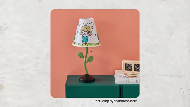 A table lamp with a hand-painted lampshade featuring a cartoon character and text