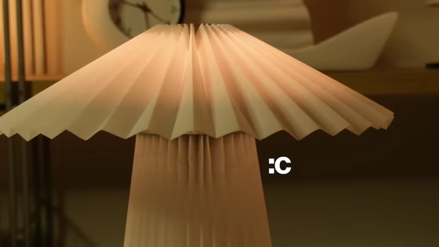 A close-up of the KUDDLAVA lamp shade with a sad face emoji indicating a crease from assembly