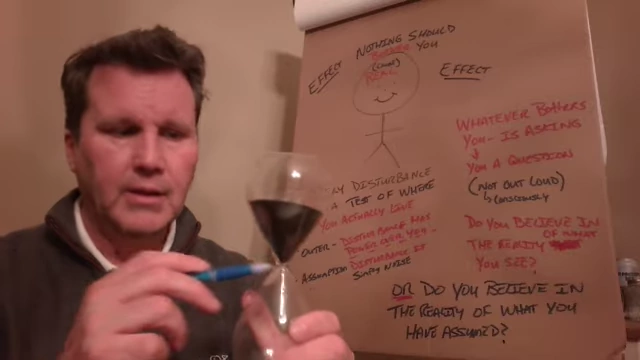 The speaker holds up an hourglass, using it as a metaphor for the constant flow of self-perception and how old thoughts can accumulate like "rust" or "corrosion" in our internal connection to source energy.