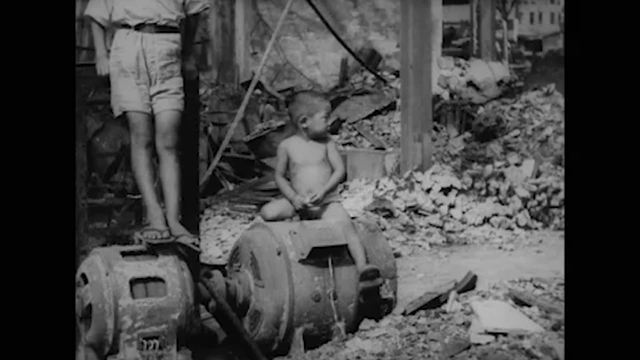 A child sitting on rubble in post-WWII Japan