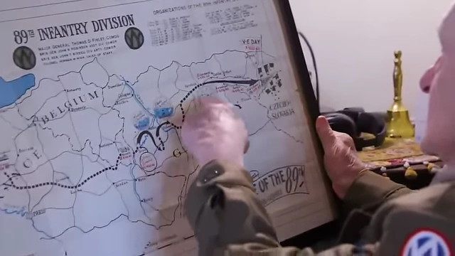 Bill Kongable points out the route of the 89th Infantry Division on a map.