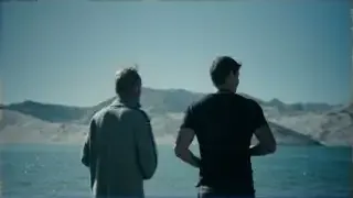 Traveler and his father marvel at the stunning blue waters of Bisha Lake amidst desert landscapes.