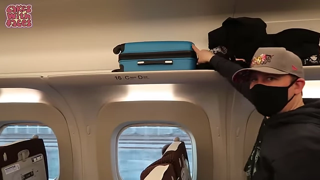 Cabin-sized suitcase being placed on an overhead luggage rack