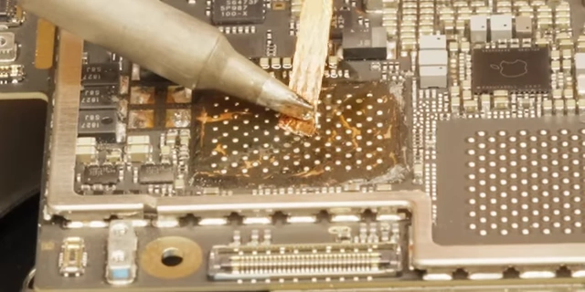 Using solder wick to clean residual solder from the pads