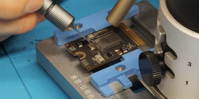 Linus scraping underfill from the Mac Mini SSD module