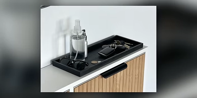 A close-up of an entryway tray containing keys, sunglasses, and other small essentials.