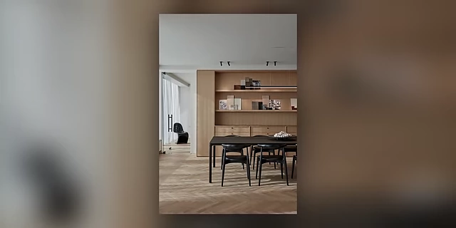 A dining area with a built-in wall unit combining open shelving and closed cabinets for comprehensive storage.