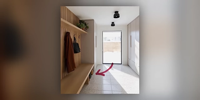 An entryway featuring a designated 'drop zone' beneath a bench for shoes, indicated by an arrow.
