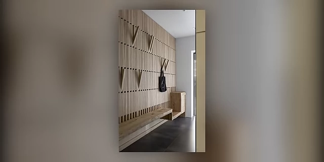 A modern wall design incorporating various hooks for coats and bags in an entryway.