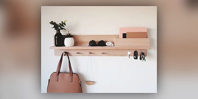 A wall-mounted shelf with hooks and designated spots for small items like keys and sunglasses.