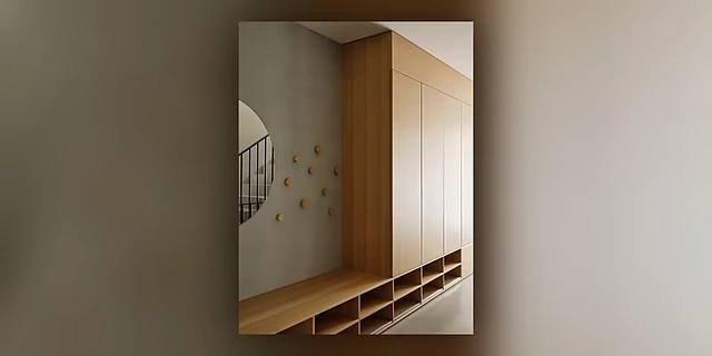 A sleek entryway featuring tall, built-in wooden closets for maximum storage.