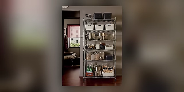 A kitchen or pantry shelving unit neatly organized with various containers, jars, and kitchenware.
