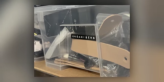 A close-up of a clear storage container with a neatly printed label 'ORGANISERS'.