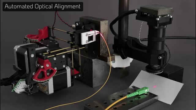 Automated setup for coupling laser light into an optical fiber, showing the micro-manipulator positioning a laser source