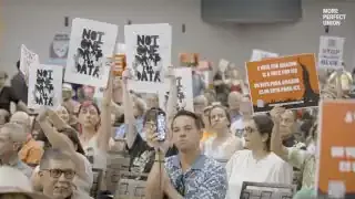 Protestors hold signs saying "Not One Drop for Data" and "Stop Project Blue" at a town hall meeting.