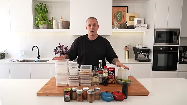 A comprehensive display of Andy's recommended pantry staples for beginner home cooks, including various flours, sugars, rices, pasta, oils, vinegars, sauces, canned goods, and essential spices.