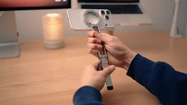 A person demonstrating the Ulanzi MagSafe tripod, showing its carabiner feature.