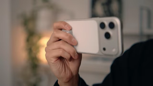 An external SSD attached to the back of an iPhone, demonstrating its compact and integrated design.