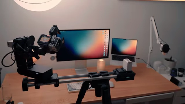 A camera mounted on an Edelkrone slider and tripod, set up to capture a tracking shot across a desk.