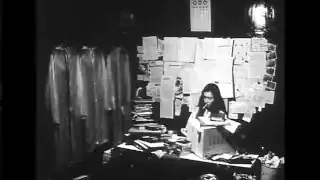 Woman intensely focused on her work at a cluttered desk