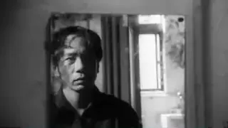 A man stares intensely at his reflection in a mirror, reflecting on his identity.