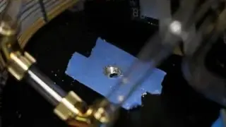 Linus carefully drills a hole in the case mid-plate