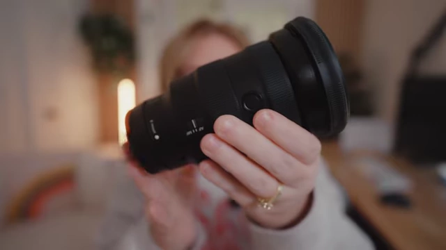 The speaker holds up her large and heavy Sony 16-35mm 2.8 lens.