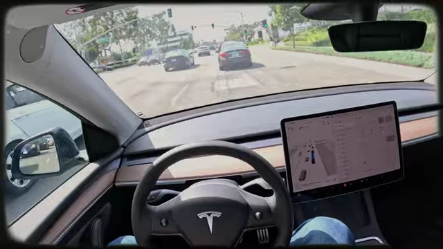 Ein Tesla-Auto fährt autonom auf einer Straße, was die fortschreitende Automatisierung im Transportwesen veranschaulicht.