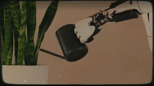 Ein humanoider Roboter gießt eine Pflanze in einem Wohnzimmer, was die Fähigkeit von Robotern zur Durchführung menschlicher Aufgaben veranschaulicht.