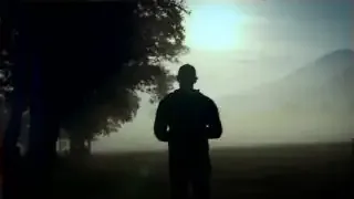 A person walking in a field during sunrise, illustrating a morning walk