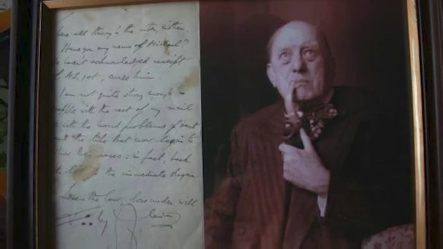 A framed letter and a photo of an older Aleister Crowley holding a pipe, illustrating his continued influence and the legacy of his work