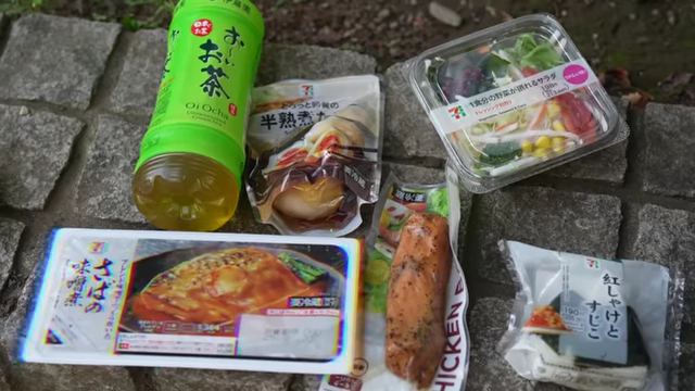 日本便利店提供的健康餐食，包括味噌炖鱼、日式拉面风味鸡蛋、饭团、烤鸡、沙拉和绿茶。