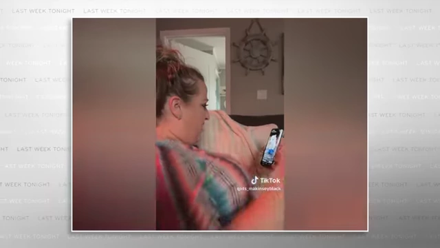 A woman reacts with disbelief upon learning an image on her phone is AI-generated