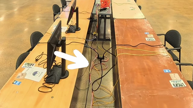 A close-up of a custom Ethernet "snake" cable bundle running along the floor between rows of gaming tables at LANFest.